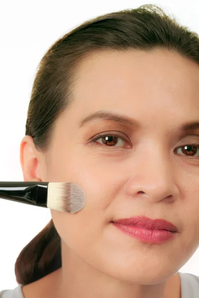 Isolated middle age asian woman with make up brush. — Stock Photo, Image