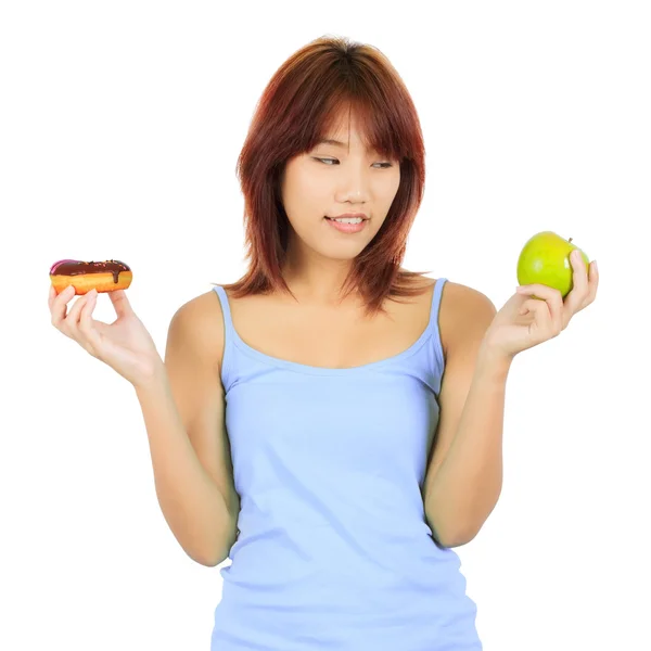 Jovem mulher asiática com uma maçã e um pedaço de donut — Fotografia de Stock