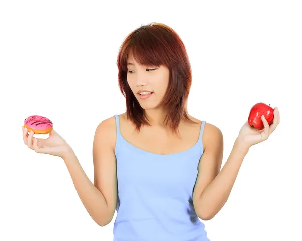 Jovem mulher asiática com uma maçã e um pedaço de donut — Fotografia de Stock