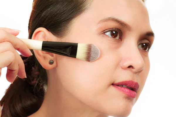 Isolated middle age asian woman with make up brush. — Stock Photo, Image