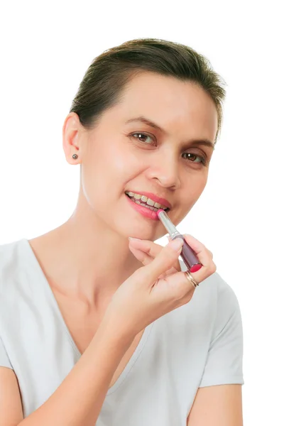 Isolated asian woman with puts on a lipstick — Stock Photo, Image