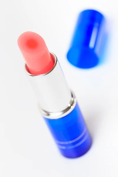 Isolado de um batom rosa com tubo azul em branco — Fotografia de Stock