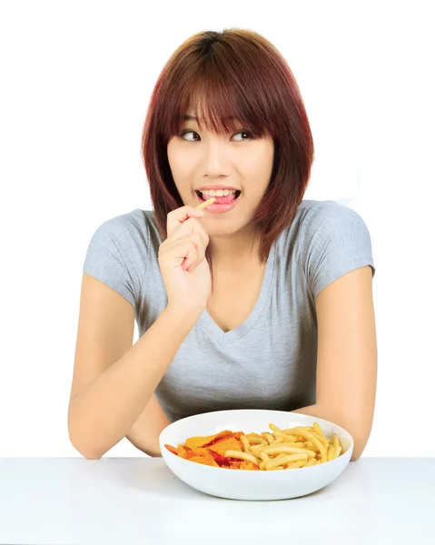 Eristetty nuori aasialainen nainen lautasella perunalastuja ja ranskalaisia perunoita — kuvapankkivalokuva