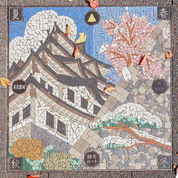 Mosaik kakel former upp nagoya castle på ett brunnslock — Stockfoto