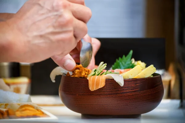 Close-up van een kom van Sashimi met handen van Japanse chef-kok — Stockfoto