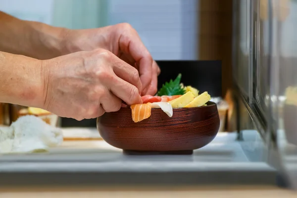 Închiderea unui castron de Sashimi cu mâinile bucătarului japonez — Fotografie, imagine de stoc