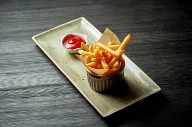 Klasik meze. Kırmızı soslu güzel bir tabakta servis edilen patates kızartması.