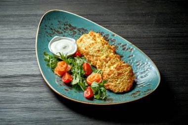 Geleneksel Ukrayna ve Belarus yemekleri - kızarmış patates krepleri (draniki, deruny) ekşi krema ve somon ile