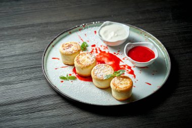 Mükemmel bir kahvaltı. Beyaz tabakta krema soslu süzme peynirli krep. Ukrayna şurubu