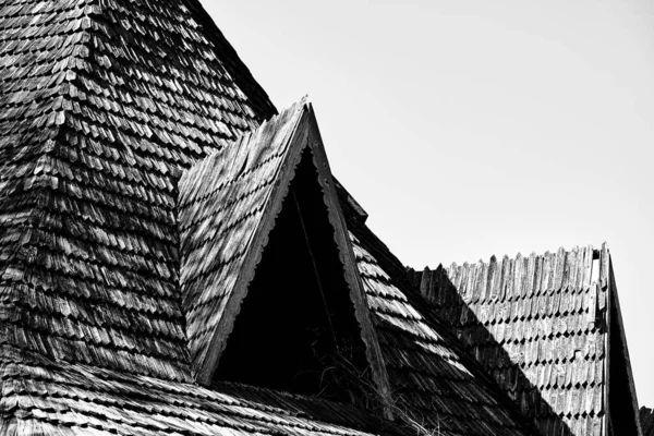 Triangular roof with wooden tiles of an abandoned house