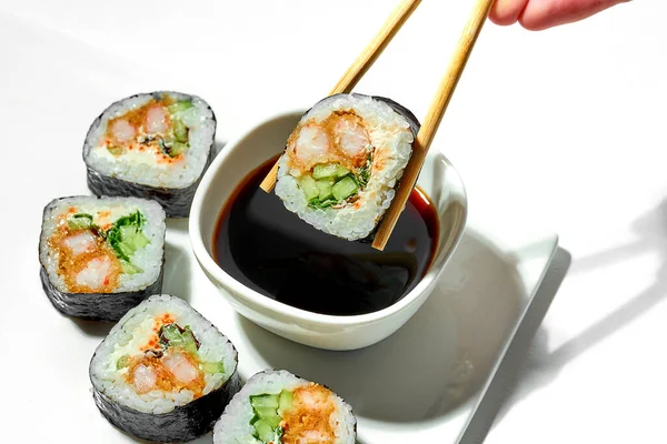 Rotolo Sushi Immergente Mano Con Gamberetti Salsa Soia Piatto Bianco — Foto Stock