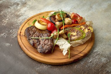 Tahta tepside ızgara sebzeli biftek.