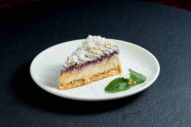 Siyah arka planda beyaz tabakta armut ve yaban mersinli cheesecake