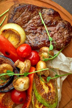 Tahta tepside ızgara sebzeli biftek.