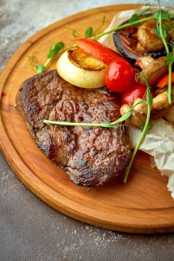 Tahta tepside ızgara sebzeli biftek.