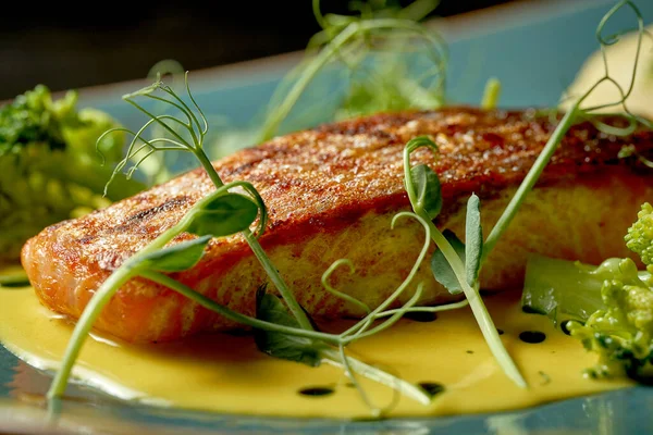 Sarı soslu somon bifteği, sebze püresi ve brokoli. Ahşap arkaplan