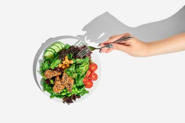 Bir kadının eli beyaz arka planda somon ve nohut salatasına uzanır. Sağlıklı Yemek Posteri