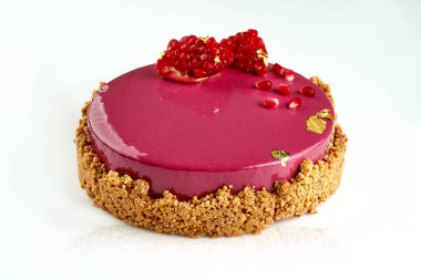 Beyaz zemin üzerinde çıtır çıtır kabuklu kremalı pasta ve nar.