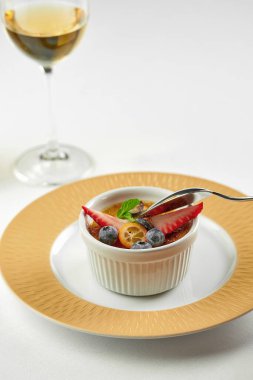 Beyaz masa örtüsü üzerinde krem karamel tabağı. Yakın plan.