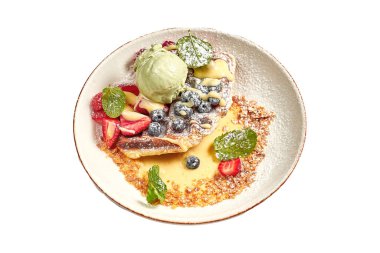 Beyaz arka planda dondurmalı Belçika waffle 'ları ve meyve kasesi.