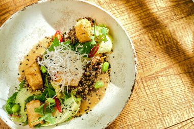 Kızarmış soya peyniri ve köri sosu ahşap arka planda bir kasede.