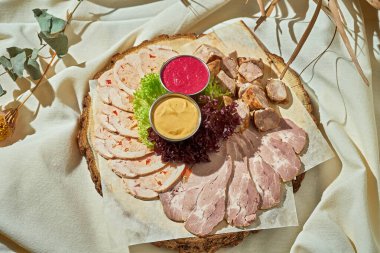 Dilimlenmiş et. Sert ışık. Beyaz masa örtüsü.