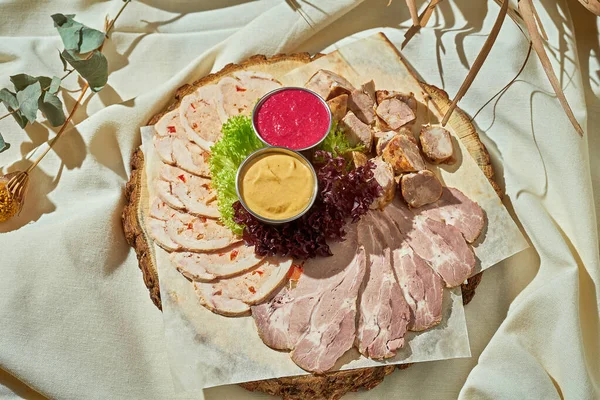 Dilimlenmiş et. Sert ışık. Beyaz masa örtüsü.