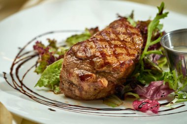 Az pişmiş biftek, marul ve sos. Seçici odak