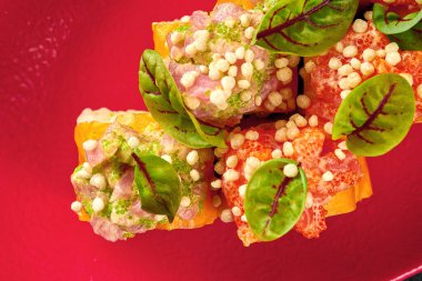 Kırmızı tabakta karides, krem peynir ve somonlu suşi.