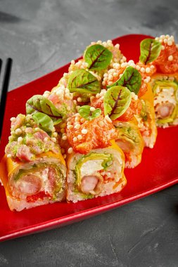 Kırmızı tabakta karides, krem peynir ve somonlu suşi.