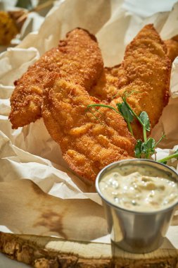 Soslu tavuk nugget. Beyaz bir masa örtüsünün üzerinde. Sert ışık. Seçici odaklanma. Yakın plan.