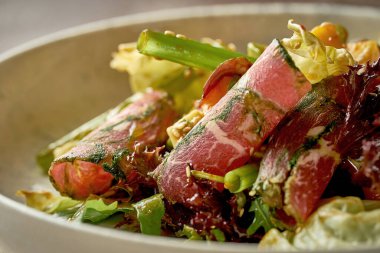 Biftekli salata ve acı soslu mango. Yakın çekim, prodüksiyon sonrası gürültü. Seçici odak