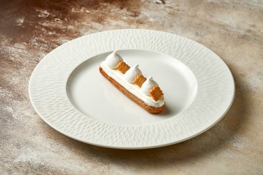 Eclair with white frosting and custard. Selective focus, close-up