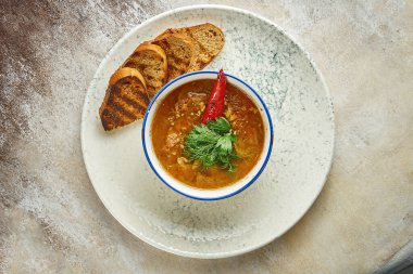 Marrocan harira soup with lamb on a white plate. Close-up, selective focus