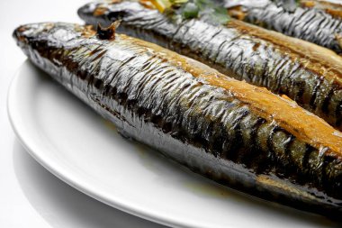 Tabakta füme uskumru. Yakın plan, seçici odaklanma. Beyaz arkaplan.