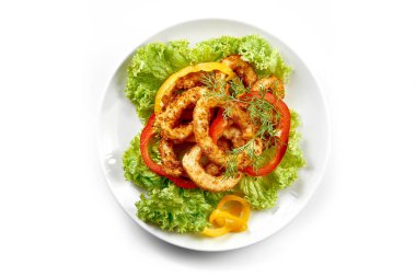 Kızarmış kalamar halkaları beyaz arka planda bir tabakta. Yakın plan. Seçici odak