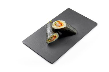Siyah tahtada Nori 'de ton balıklı suşi burrito. Yakın plan, seçici odaklanma. Beyaz arkaplan.