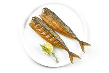 Beyaz arka planda beyaz bir tabakta tütsülenmiş uskumru. Yakın çekim, seçici odaklanma.