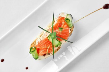 Beyaz arka planda beyaz bir tabakta somon ve krem peynirli Yakın çekim, seçici odaklanma