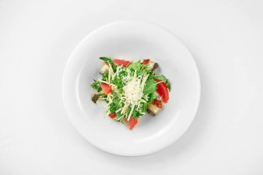 Beyaz arka planda beyaz bir tabakta yılan balığı ve greyfurtlu salata. Yakın çekim, seçici odaklanma