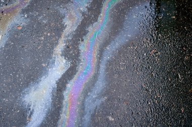 Motor yağı, gaz veya asfalta dökülen petrolün soyut arkaplanı