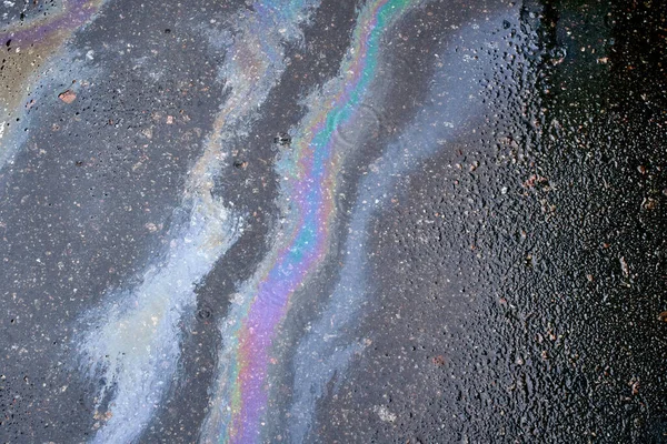 Motor yağı, gaz veya asfalta dökülen petrolün soyut arkaplanı