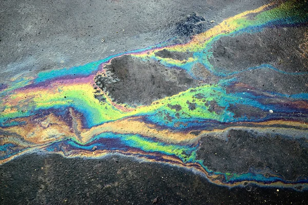Abstract background of motor oil, gas or petrol spilled on asphalt in a parking lot