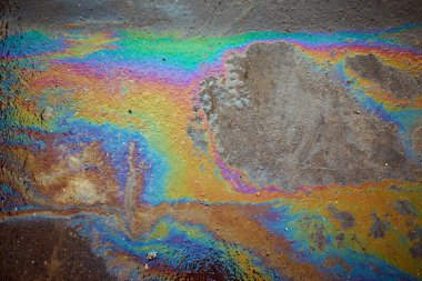 Asfalttaki yağ lekesi, Asfalt Yolu 'ndaki benzin lekeleri doku ya da arka plan olarak. Yanardöner benzin lekeleri..