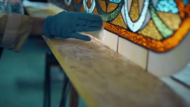Közelkép A művész mintázza a kész festett üvegablakot. Kézműves, kézzel készített. Foltos üvegműhely. Tiffany technika. — Stock videók