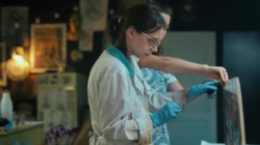 İki kadın sanatçı mozaik cam pencereye paten sürerler. El yapımı el yapımı. Tiffany tekniği.