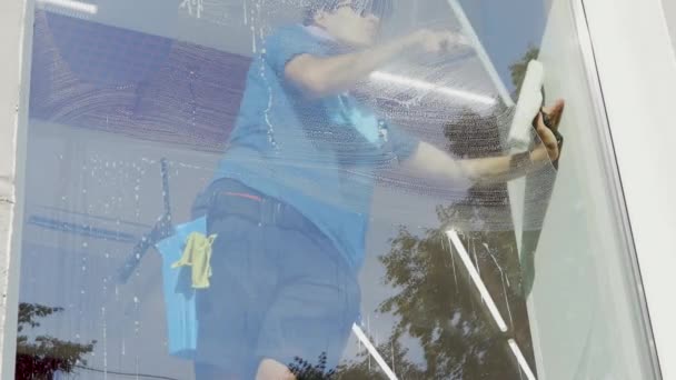 Egy profi takarító speciális habbal mossa és tisztítja az ablakokat.. — Stock videók