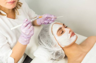 Yüz bakımı ve korunma. Güzellik uzmanının randevusundaki genç bir kadın.