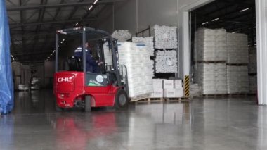 Ufa, Rusya, 30 Haziran 2020. Polipropilen üretim tesisi. Forklift kullanan bir adam büyük bir depoda çalışır ve bir çanta dolusu hammaddeyi boşaltır.