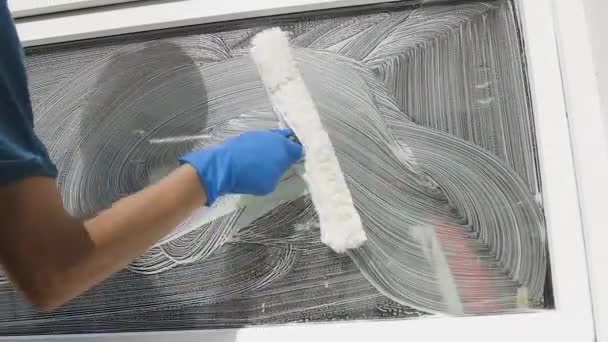 Profesionální mužský pracovník v montérkách se věnuje čištění a mytí oken se speciální pěnou a nářadím ve zpomaleném pohybu — Stock video